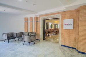 A modern interior with a reception area, a sign for 'berry taste' main restaurant, and a seating area with chairs and a table.