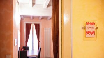 Un pasillo que conduce a una habitación con un letrero que dice 'PAPAVERO' en una puerta amarilla.