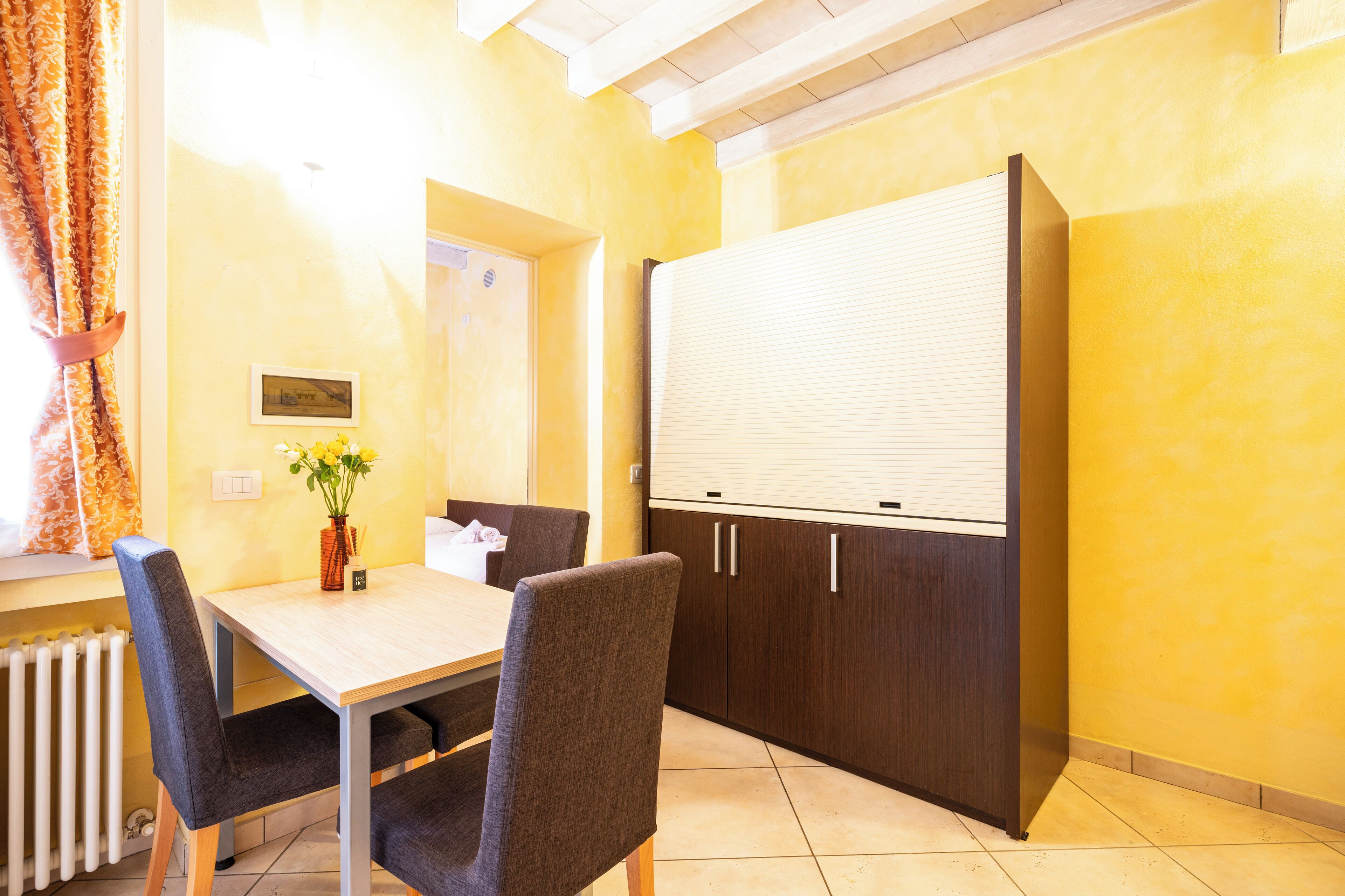 A conference room with a large whiteboard, dark wooden cabinets, and a table with chairs.