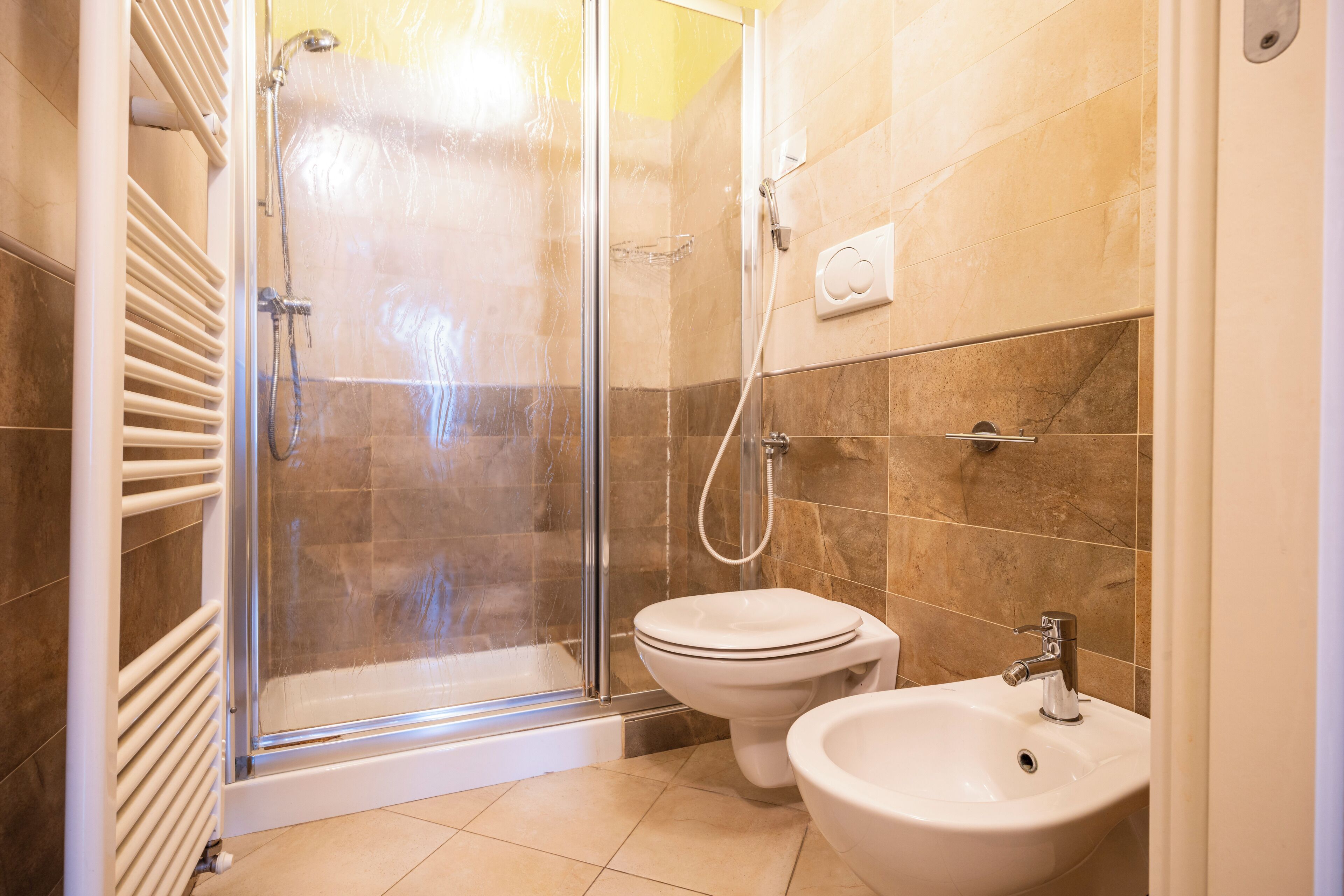 Une salle de bain avec une douche à parois de verre, des toilettes et un lavabo.