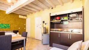 A compact hotel room with a kitchenette, a dining area, and a bed. - Al Podestà (Mantua)