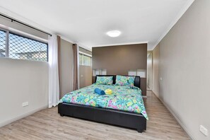 A bedroom with a bed, a window, and a ceiling light.
