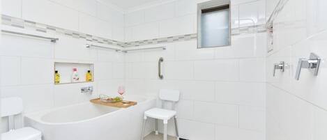 A modern bathroom with a freestanding bathtub, a shower, and a toilet.