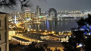 Paisatge urbà nocturn amb un pont destacat i edificis al costat del port.