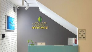 Eine Rezeptionstresen mit dem Logo von 'Mint Boutique Apartment'.
