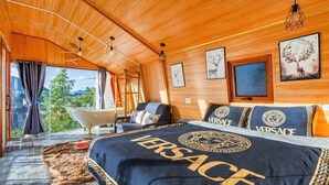 Un dormitorio con una cama grande, una bañera y vistas al exterior.