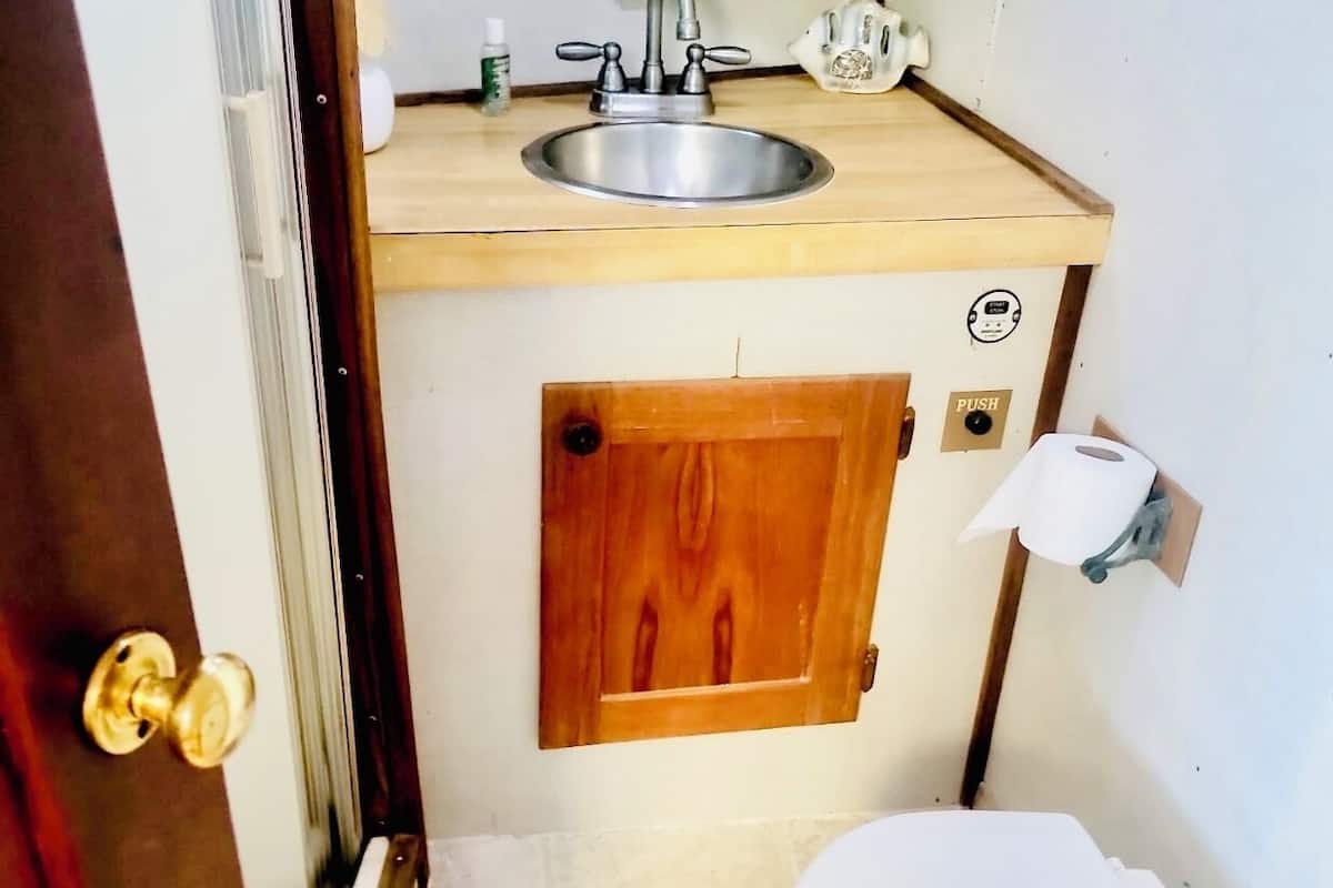Une petite salle de bain avec un meuble-lavabo en bois, un lavabo et des toilettes.
