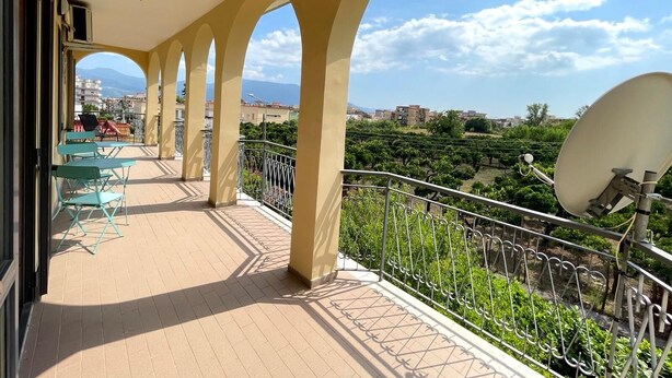 A balcony with a view of a vineyard and distant buildings. - VESUVIUS GARDEN 10 MINUTES FROM POMPEI (Boscoreale)