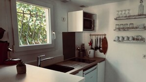 Et moderne køkken med et vindue, en mikrobølgeovn og en vask.