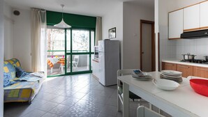 Un espacio habitable pequeño con kitchenette, comedor y sofá.