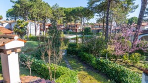 Zona residencial con jardín, piscina y varias edificaciones con techos de tejas rojas.