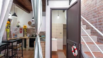 A compact kitchen with a dining area, a staircase, and a living space.