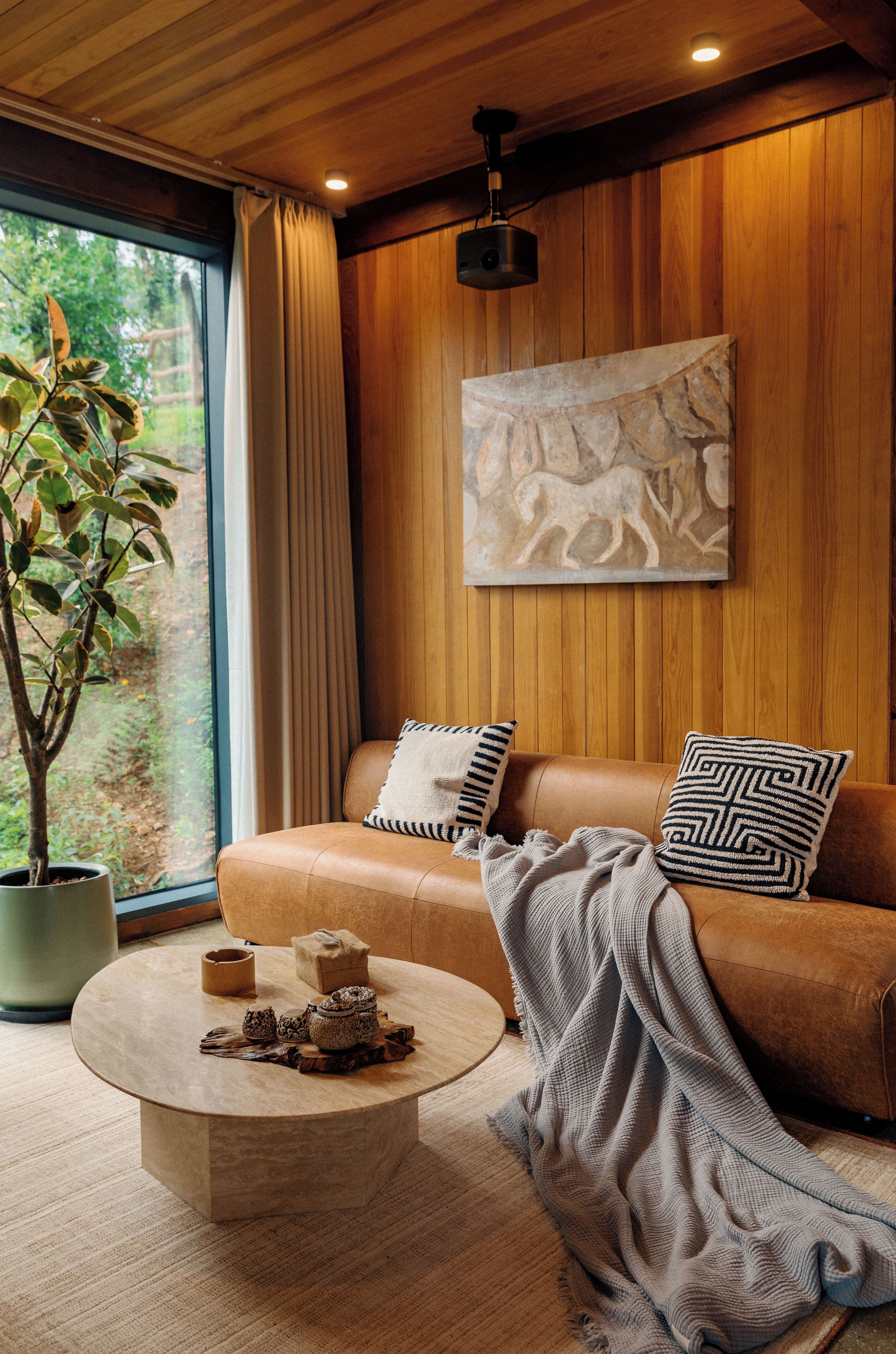 Ein gemütliches Wohnzimmer mit einem Ledersofa, einem runden Couchtisch und einem Blumentopf.