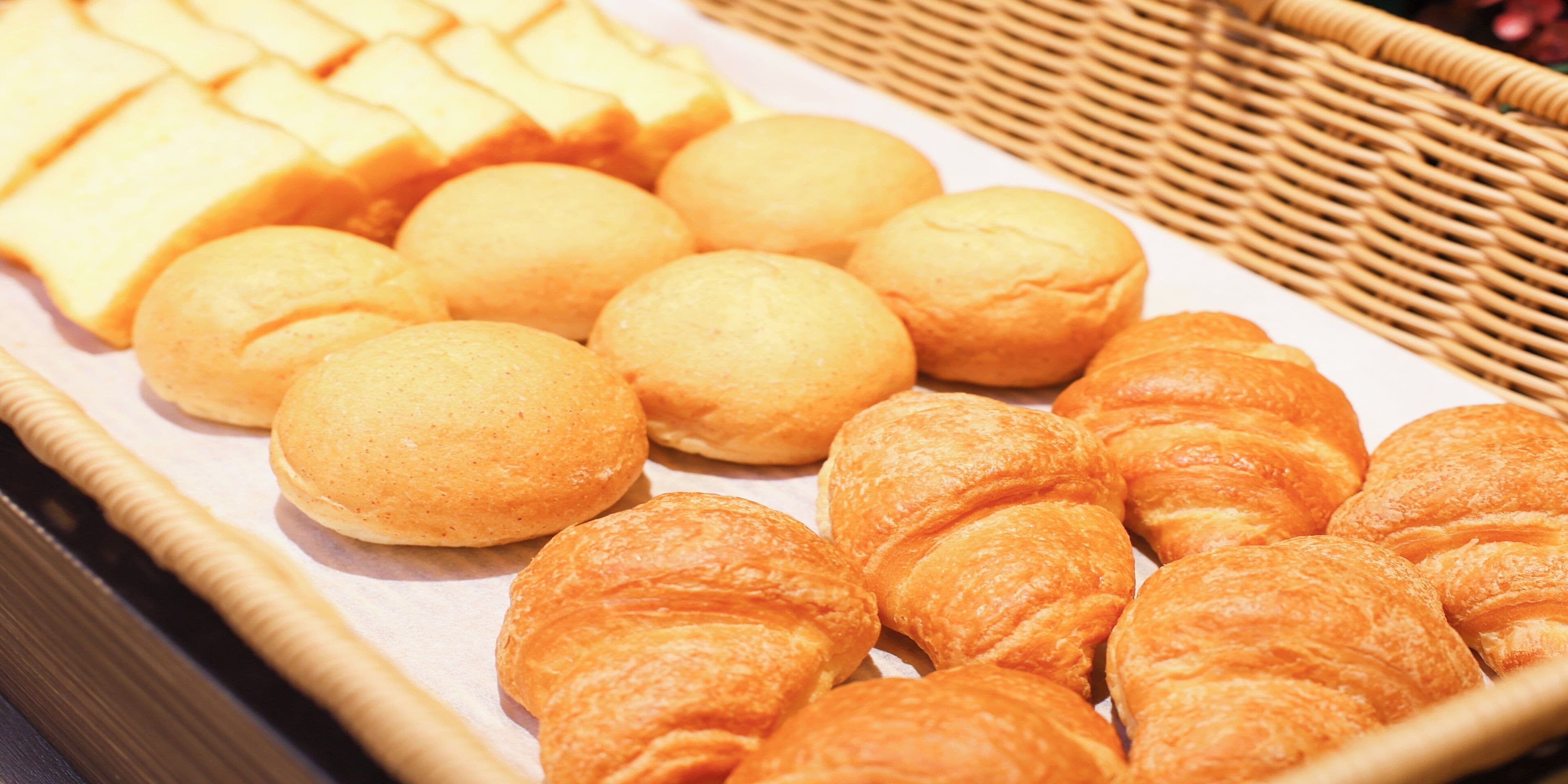 Exposició de diferents productes de forneria, incloent pa i pastissos, disposats sobre una safata.
