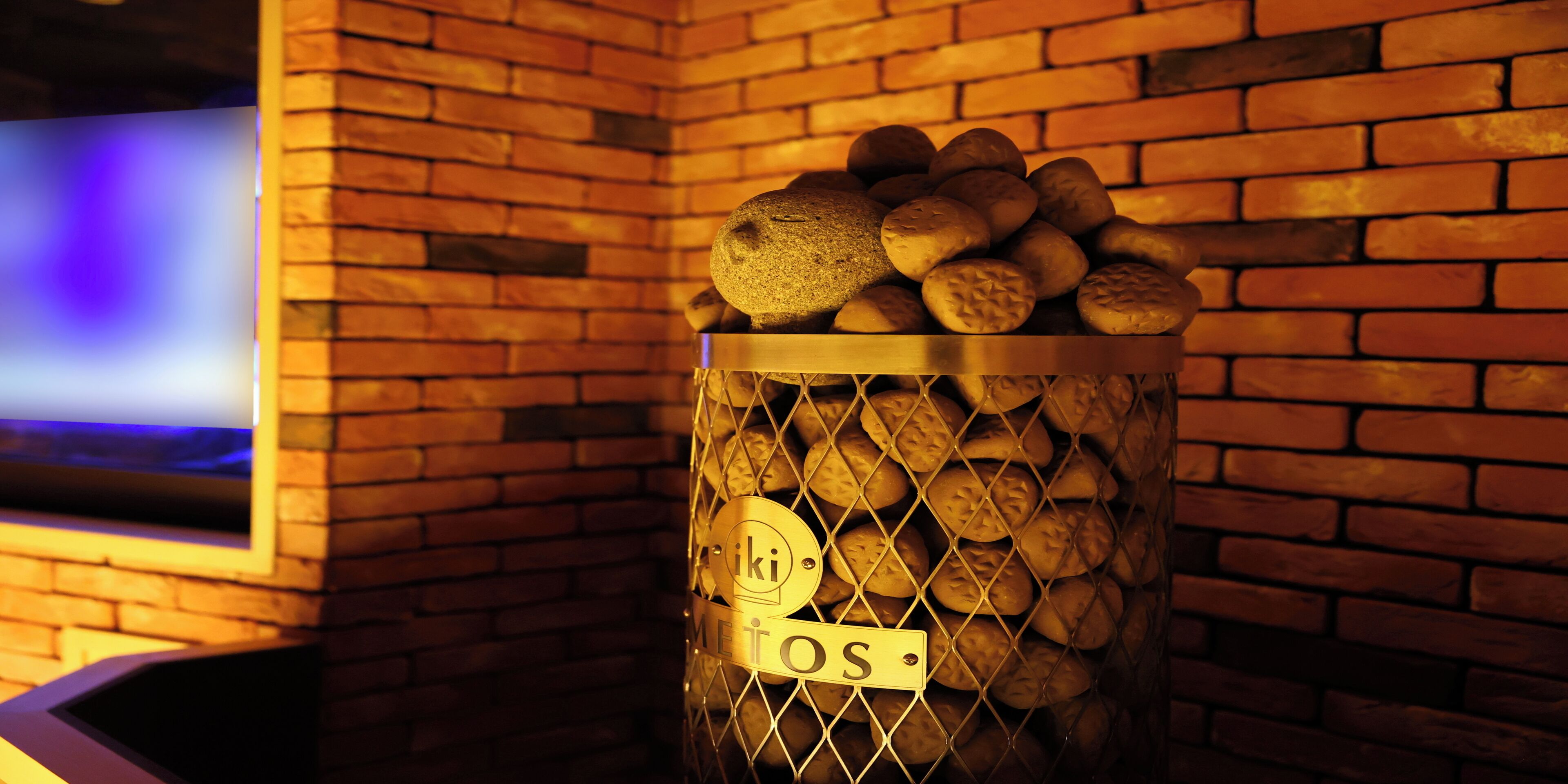 A basket filled with bread rolls against a brick wall.