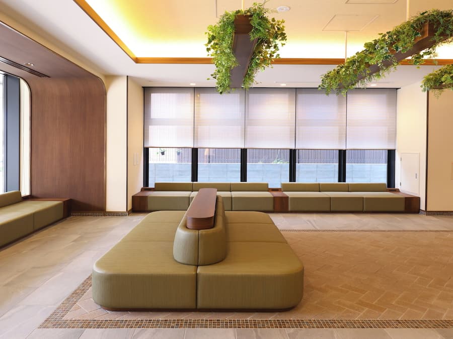 Un vestíbulo moderno con zonas de estar, ventanas amplias y plantas de interior.