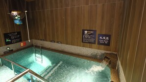 A hot tub with wooden walls and a sign indicating it is a cold bath.