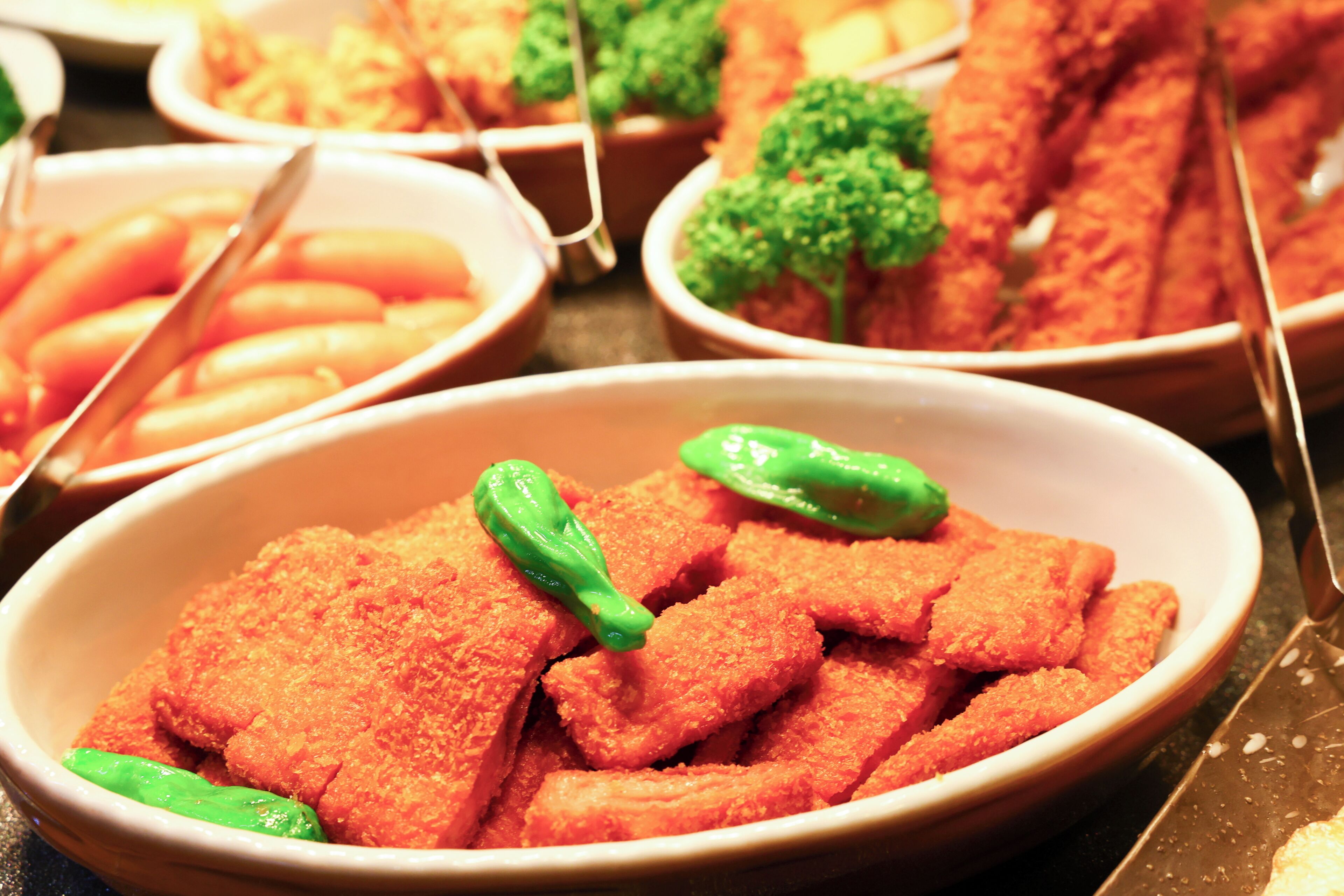 A buffet with various dishes including breaded items and vegetables.