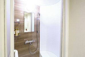 A modern bathroom with a shower, a toilet, and a sink.