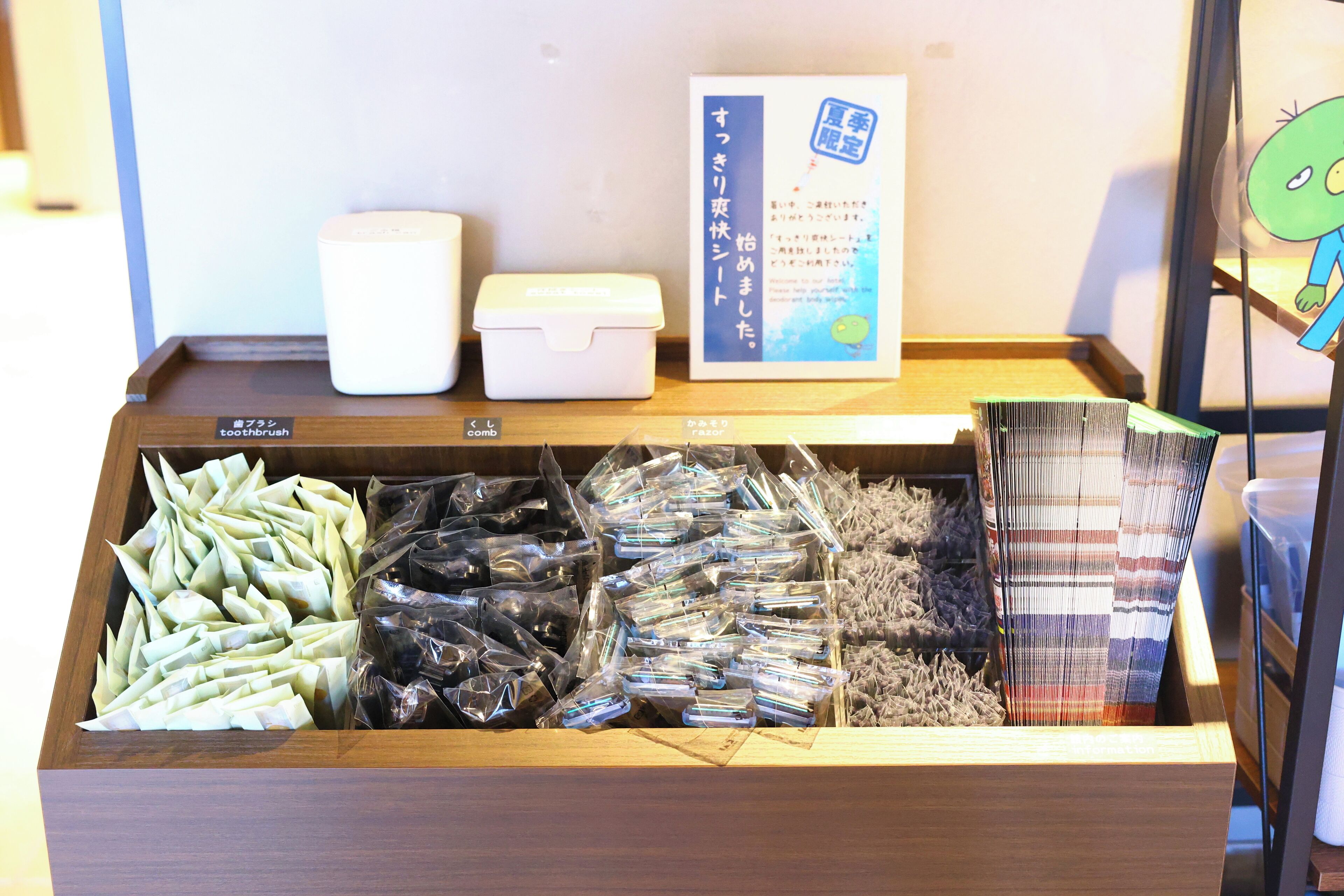 A wooden display case with various packaged items, including what appears to be snacks or food items, and a sign with Japanese text.