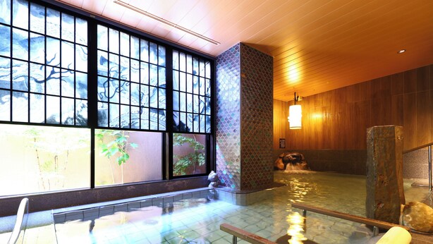 Een traditionele Japanse onsen met een houten interieur, een stenen muur en uitzicht op een tuin door grote ramen.