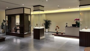 A modern reception area with a glass partition, a reception desk, and a potted plant. - Harmony Zen Retreat in Jiuzhai Valley (Ngawa Autonomous Prefecture)