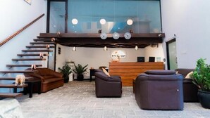 A lobby with a reception desk, a staircase, and seating areas. - Rock Fort Beach Resort (Unawatuna)