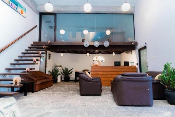 A lobby with a reception desk, a staircase, and seating areas. - Rock Fort Beach Resort (Unawatuna)