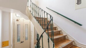 A staircase with green balusters and wooden steps leading to a landing. - Studio Apartment Located Central Lisbon (Lisbon)