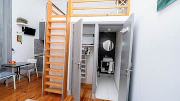 Um espaço compacto com cama beliche, área de refeições e cozinha compacta.