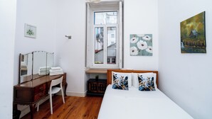 A bedroom with a bed, a dresser, a mirror, a window, and wall art. - 2 Bedroom Apartment Located Heart of Lisbon City (Lisbon)