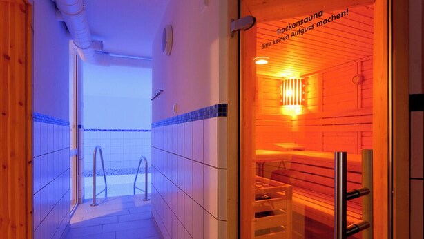 A sauna room with wooden walls and a tiled floor.