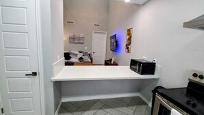 A compact kitchen with a microwave, oven, and a white countertop.