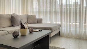 Een moderne woonkamer met een bank, een salontafel en decoratieve objecten.