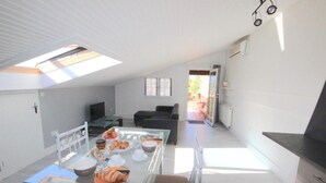 Eine moderne Küche mit einem Glastisch, einer Couch und einem Fernseher.
