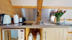 Una cocina compacta equipada con hervidor, tostadora y un reloj digital.
