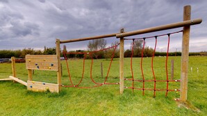 Un parque infantil con estructuras para escalar y una red de cuerdas.