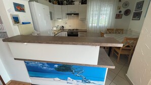 Una cocina compacta con comedor, que incluye un refrigerador, estufa y alacenas.