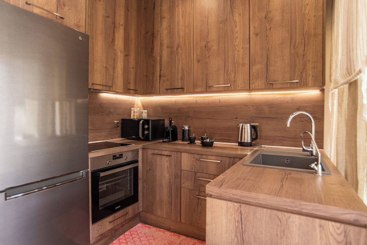Eine moderne Küche mit Holzschränken, Edelstahlgeräten und einer integrierten Spüle.