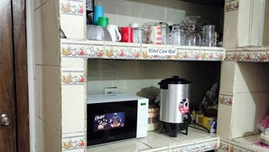 A kitchen with a microwave, coffee maker, and a compact refrigerator.