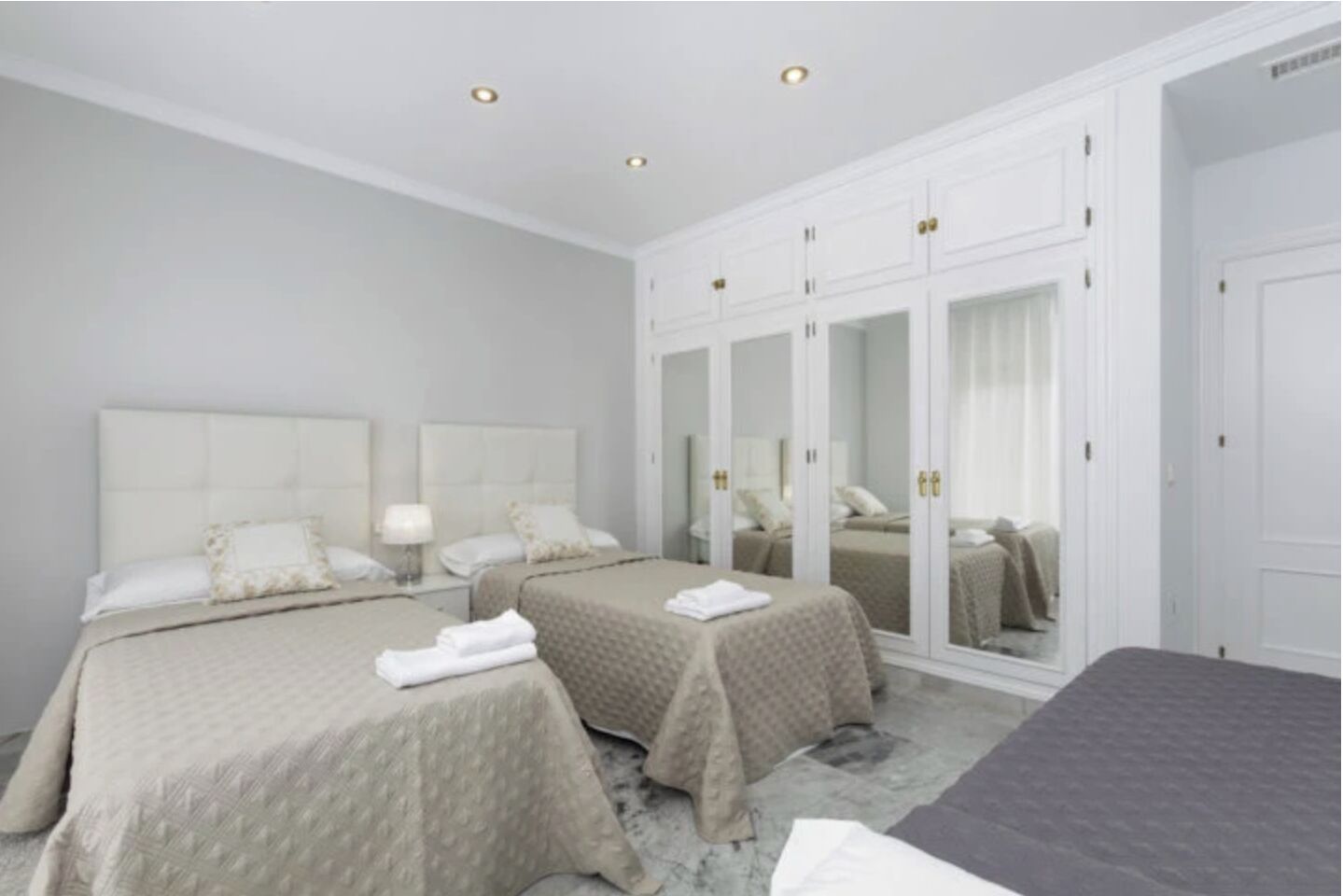 Ein Hotelzimmer mit zwei Betten, einem großen Kleiderschrank und einem Schminkspiegel.