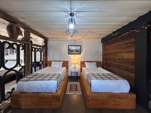 A room with two wooden beds, a hanging light fixture, and a framed picture on the wall. - Hnameni Bovadzor Lodge (Bovadzor)