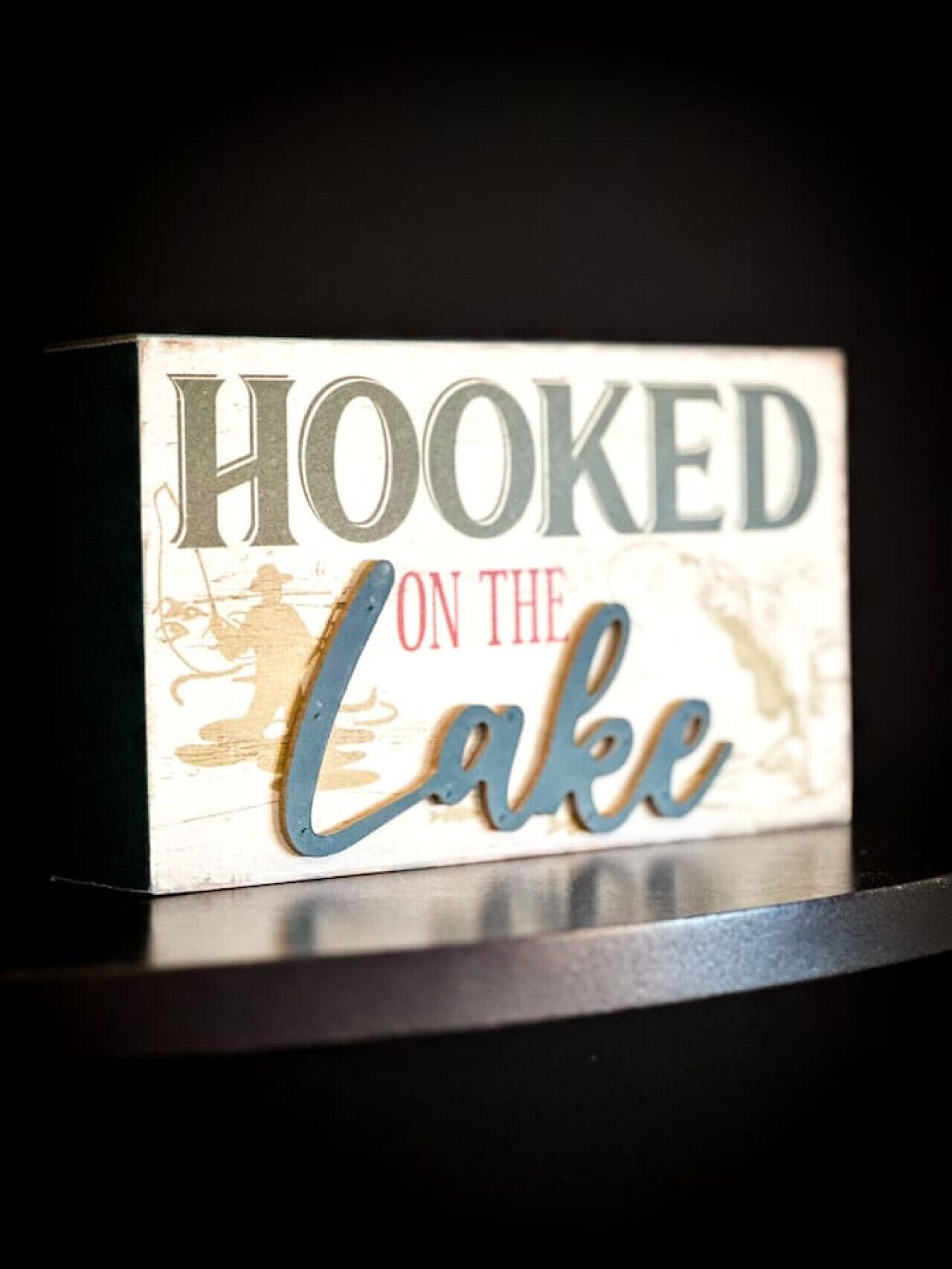 A sign with the text "HOOKED ON THE LAKE".