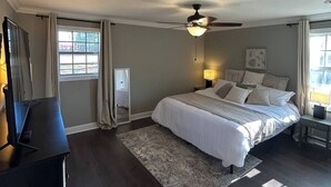 A bedroom with a bed, a desk, a ceiling fan, and a window. - Sleeps 6-8; Across from Sand Mountain Park (Albertville)