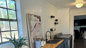 A kitchen with a wooden countertop, blue cabinets, a large window, and a rug. - Sleeps 6-8; Across from Sand Mountain Park (Albertville)