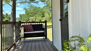 A porch with a bench, a door, and a view of trees and sky. - Sleeps 6-8; Across from Sand Mountain Park (Albertville)