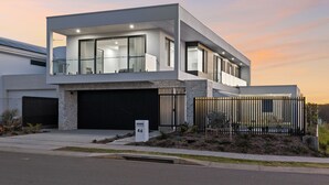 A modern two-story house with a garage, a balcony, and a fenced yard. - Elysium - Skennars Head (Skennars Head)