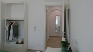 A room with a walk-in closet, a radiator, and a potted plant. - OrangeSun Holiday Home x5 with parking (Massa Lubrense)