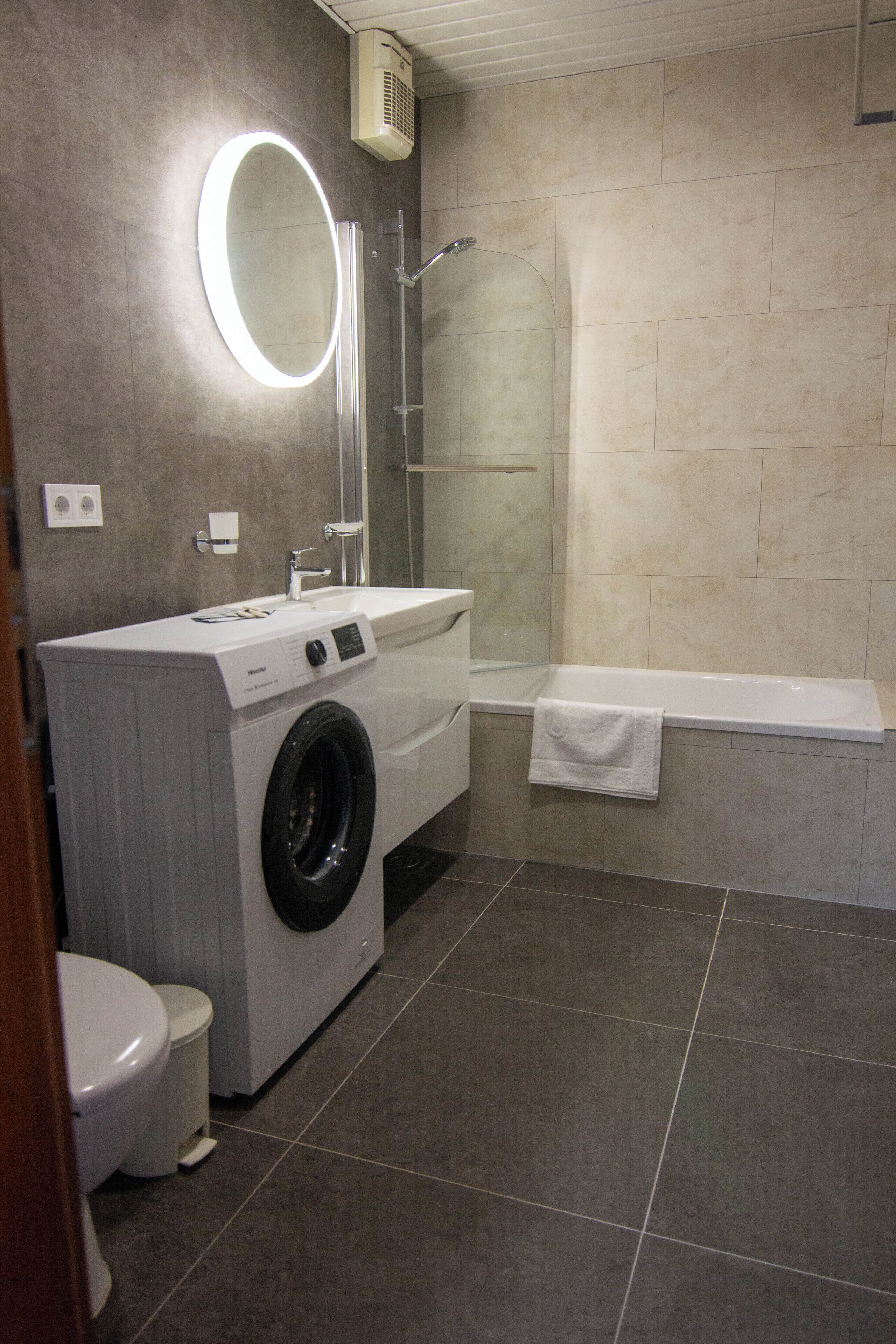 Un baño moderno con lavadora, inodoro y bañera.