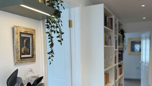 A modern kitchen with a wooden countertop, a built-in stove, and a hanging plant.